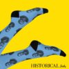 Martin Luther King socks in blue worn with legs raised on light background