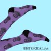 Purple Ernest Hemingway socks with black heels and toes, worn on raised legs