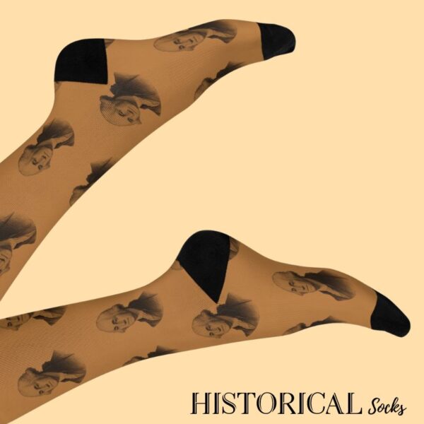 George Washington socks in brown, shown on legs raised with visible portrait pattern