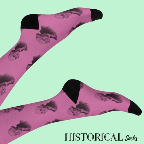 Pink George Washington socks worn on legs raised against light pink or neutral background