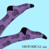 Harriet Tubman Socks in purple with black toe and heel, worn on raised legs