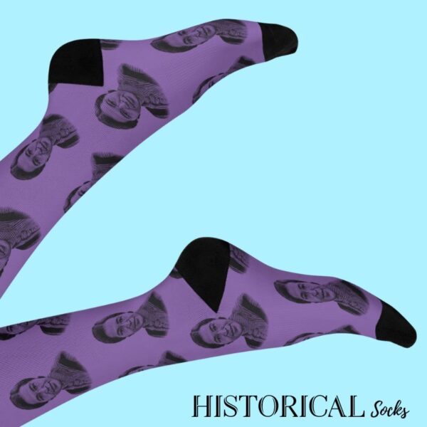 Legs raised wearing Rosa Parks Socks in purple on a soft blue background, showing the full design and stretch.