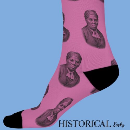 Pink Harriet Tubman socks with black toes and heels, featuring repeating portraits, worn by model standing side view.