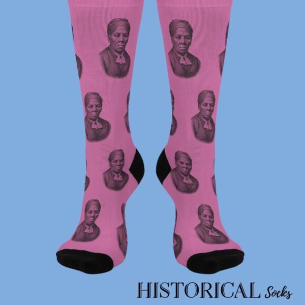 Front view of pink Harriet Tubman socks with black toe and heel accents, modeled on standing feet.