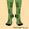 Frontal view of green Mandela socks with repeated portrait design and black detailing
